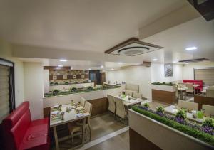 a restaurant with tables and chairs in a room at Hotel iStay in Coimbatore