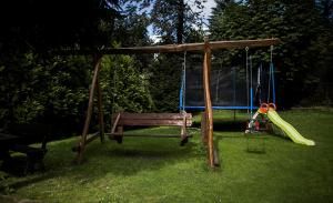 a playground with a swing and a slide at Willa Pod Lasem in Kościelisko