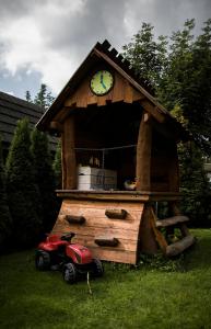 a small wooden play house with a clock on it at Willa Pod Lasem in Kościelisko