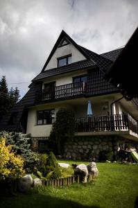 a large house with some sheep in the yard at Willa Pod Lasem in Kościelisko