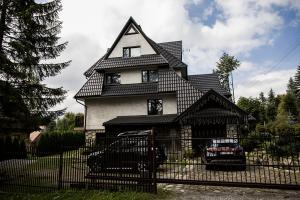 a house with a car parked in front of it at Willa Pod Lasem in Kościelisko