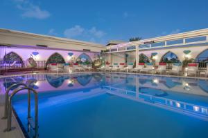 une piscine dans un hôtel avec des chaises et des tables dans l'établissement Merit Lefkosa Hotel & Casino, à Lefkosa Turk