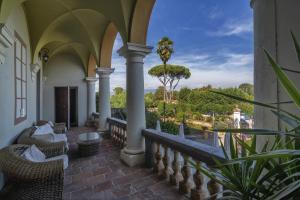 een balkon met stoelen en uitzicht op de oceaan bij Hotel Villa Cheli in Lucca