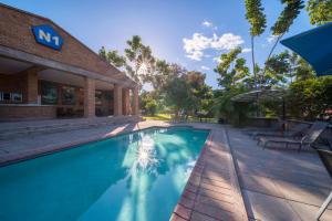 una piscina frente a un edificio en N1 Hotel & Campsite Victoria Falls, en Victoria Falls