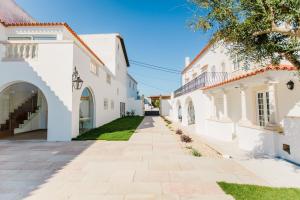 un vicolo tra due edifici bianchi di Sra da Oliveira Solar Heritage a Leiria