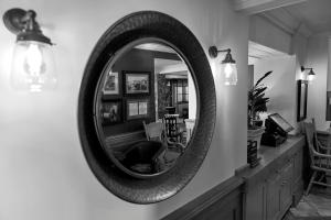 - un miroir rond sur un mur dans le salon dans l'établissement The Bluebird Inn at Samlesbury, à Preston