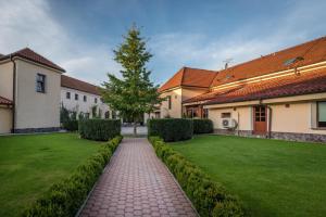 een tuin met een stenen loopbrug voor een huis bij Chateau Krakovany in Krakovany