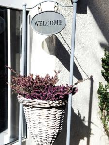 ein Korbkorb mit einem Willkommensschild vor einer Tür in der Unterkunft Boutique Hotel Villa Stockum in Düsseldorf