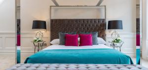 a bedroom with a large bed with pink pillows at Kilkenny Hibernian Hotel in Kilkenny