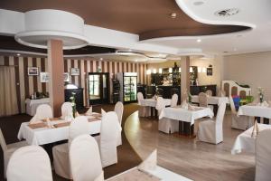 un ristorante con tavoli bianchi e sedie bianche di Hotel Ossowski a Swarzędz