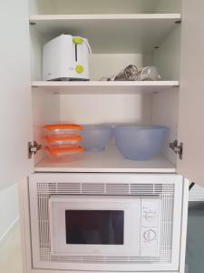 una cocina con microondas y cuencos en las estanterías en Apartamento Orlando - Costa Adeje, en Adeje