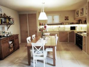 een keuken met een houten tafel en witte stoelen bij Il Glicine Di Lucca in Lucca