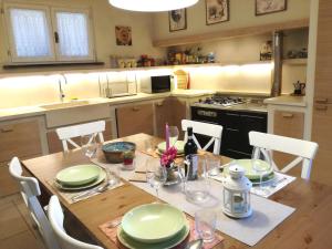 een keuken met een houten tafel met groene gerechten erop bij Il Glicine Di Lucca in Lucca