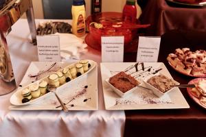 een tafel met verschillende soorten gebak en desserts bij Hotel Banderium in Komárno