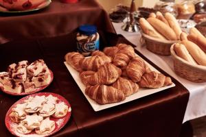 een tafel met borden gebak en brood bij Hotel Banderium in Komárno