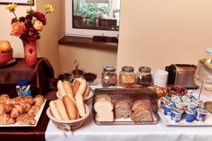 een tafel met verschillende soorten brood en gebak erop bij Hotel Banderium in Komárno