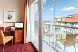 キュールングスボルンにあるMorada Strandhotel Ostseebad Kühlungsbornのデスク付きのオフィス、景色を望むバルコニーが備わります。