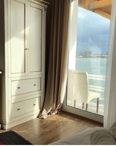 een slaapkamer met een raam met een stoel en een dressoir bij Ventus Harbor Hotel in Durrës