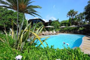 - une piscine avec des chaises et des parasols dans un complexe dans l'établissement Lodge de Charme A Cheda, à Bonifacio