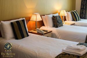 um quarto de hotel com duas camas e um telefone em The Belfray Country Inn em Derry Londonderry