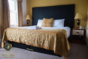 um quarto com uma cama grande e uma cabeceira preta em The Belfray Country Inn em Derry Londonderry