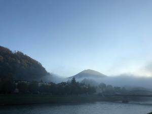 un puente sobre un río con una montaña en el fondo en Sarah's Altstadt Oase Salzburg, en Salzburgo