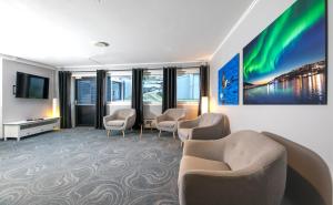 une chambre d'hôtel avec des chaises, une télévision et une salle d'attente dans l'établissement Thon Partner Hotel Narvik, à Narvik