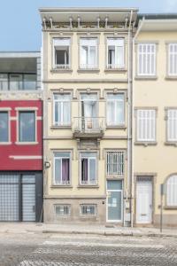 um edifício amarelo alto com janelas e uma varanda em SwissPorto Guest House no Porto