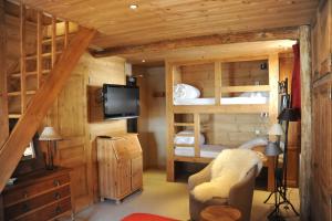 um quarto com 2 beliches e uma televisão em Hôtel Chalet Alpage em La Clusaz