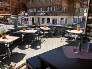 eine Terrasse mit Tischen und Stühlen in einem Gebäude in der Unterkunft Hotel Viktoria Eden in Adelboden