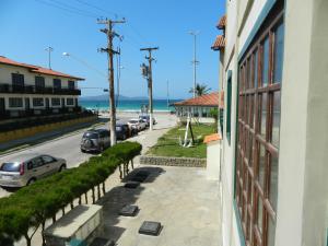 a view of a street with cars parked on the beach at Cond. Hotel Âncora em frente Praia do Peró in Cabo Frio