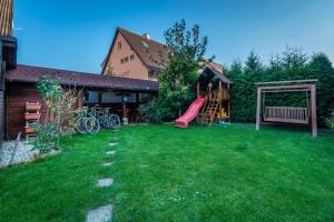 einen Hof mit einem Spielplatz mit Rutsche und einem Haus in der Unterkunft Vila House Family in Poprad