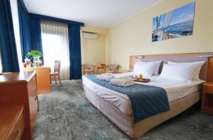 a hotel room with a bed with a tray of food on it at Hotel Mrągowo Resort&Spa in Mrągowo