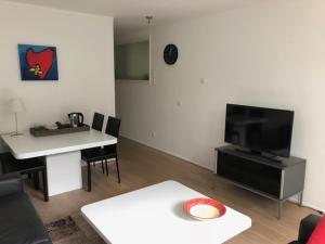 Appartement BBwB في بريدا: غرفة معيشة مع طاولة وتلفزيون