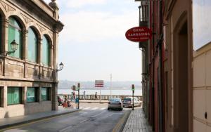 a street with cars parked on the side of a building at Apartamentos Plaza Mayor in Gijón