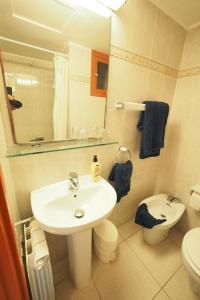 a bathroom with a sink and a toilet and a mirror at Hotel Montserrat in Sitges