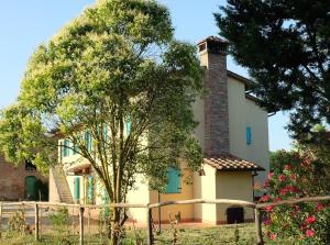 une maison avec un arbre en face dans l'établissement Podere l'Ulivo, à San Miniato