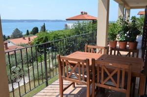 balcone con tavolo, sedie e vista sull'acqua di Apartments Ostanek 2 a Portoroz