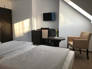 1 dormitorio con 2 camas, mesa y TV en Villa Diana, en Rozalin