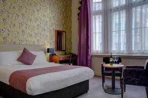 una camera d'albergo con letto, tavolo e sedie di Heywood House Hotel, BW Signature Collection a Liverpool