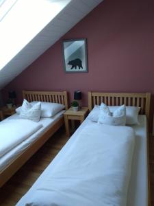 2 Betten in einem Zimmer mit roter Wand in der Unterkunft Rheinauer Hof - bed & breakfast in Mannheim