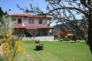 una casa con un cortile verde davanti di Villa Filokosta a Pertouli (Pertoúlion)