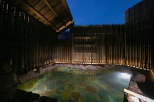 uma piscina com uma cerca de madeira ao lado de uma piscina em Yufuin Bath Satoyamasafu em Yufu