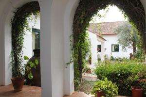 une arche avec du lierre sur le côté d'une maison dans l'établissement Quinta do Caçador, à Estremoz