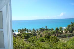 a view of the beach and the ocean from a house at Breeze Cottage in Five Islands Village