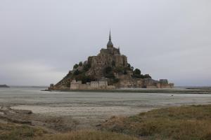 une île dans l'océan avec un château sur elle dans l'établissement Le Mouton Blanc, au Mont-Saint-Michel