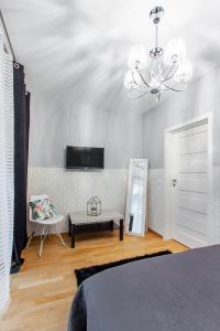 a bedroom with a bed and a chandelier at ClickTheFlat Sienna Center Apart Rooms in Warsaw