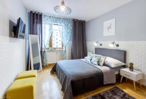 a bedroom with a bed and a yellow chair at ClickTheFlat Sienna Center Apart Rooms in Warsaw