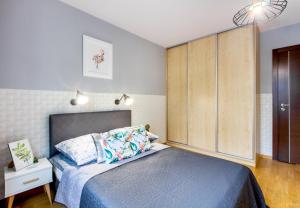 a bedroom with a bed and a large wooden cabinet at ClickTheFlat Sienna Center Apart Rooms in Warsaw