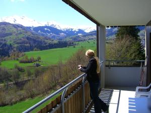 uma mulher de pé numa varanda com vista para as montanhas em Apartment in Disentis em Disentis